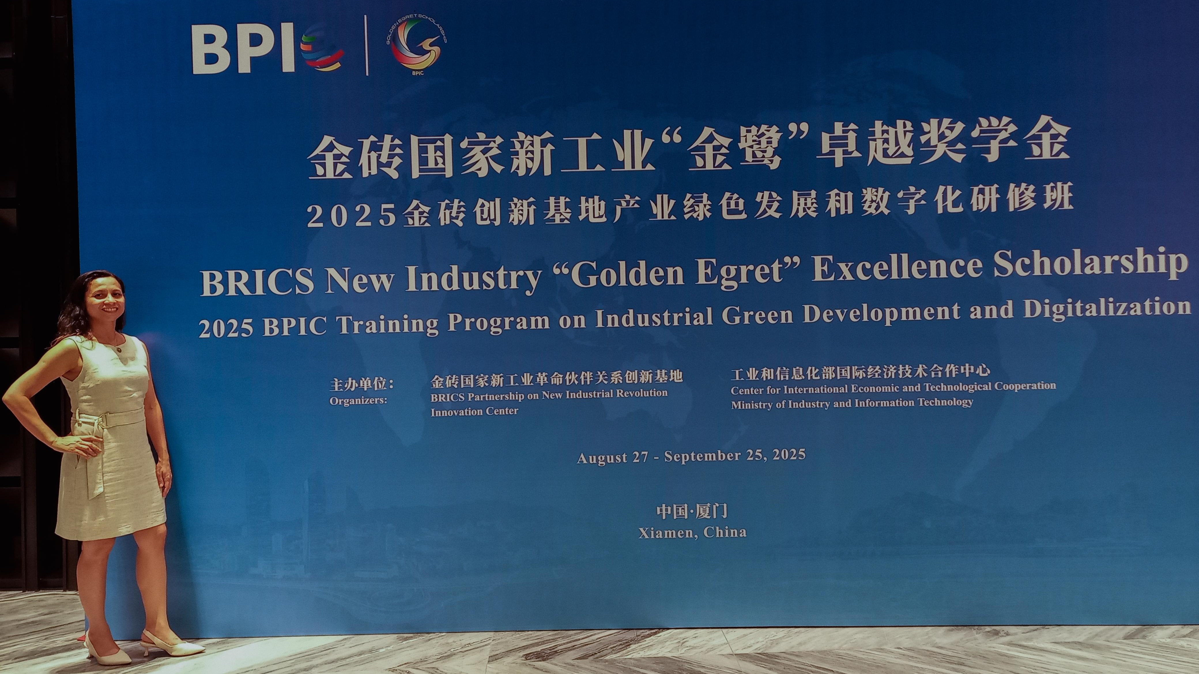 Lucineide posa para a foto na frente de um painel